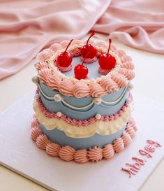 a birthday cake decorated with cherries and frosting