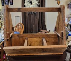 an old wooden box is sitting on a table in front of a chair and other items