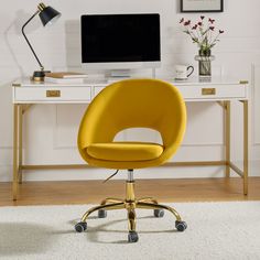 a yellow office chair sitting in front of a computer desk with a monitor on it