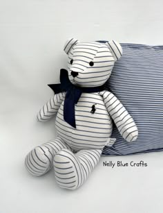 a striped teddy bear sitting next to a pillow