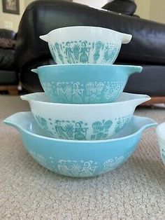 five blue and white bowls stacked on top of each other in front of a couch