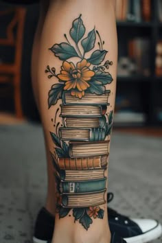 a woman's leg with books and flowers on it