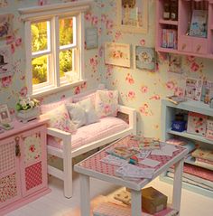 a doll house with furniture and accessories in the living room, including a couch, table, bookshelf and window