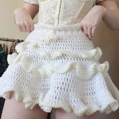 a woman wearing a white crochet skirt with ruffles