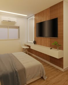 a large flat screen tv mounted to the side of a wall next to a bed