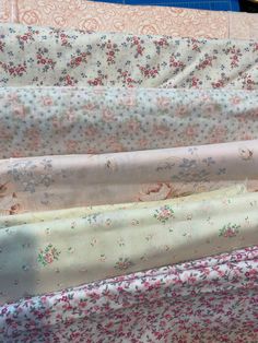 several different types of fabric laid out on top of each other, including pink and blue flowers