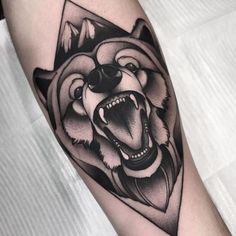 a black and white bear tattoo on the arm