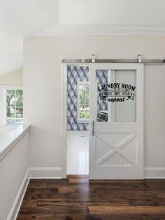 an empty room with a white door and blue patterned wall paper on the window sill