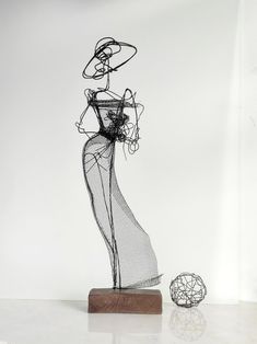 a wire sculpture is shown next to a ball