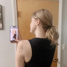 a woman is taking a selfie with her cell phone in front of the door