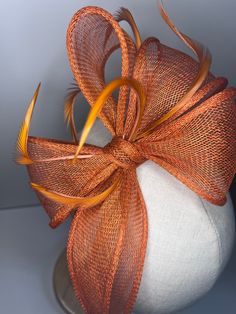 Burnt Orange high-quality sinamay bow attached to coordinating headbands for easy wear. Each fascinator is crafted by hand, ensuring that no two pieces are exactly alike. Our bow design fascinators are available in a variety of colors to match any outfit. Whether you're looking for a bold pop of color or a subtle neutral tone. 🖤This head piece looks simply stunning and is perfect for weddings, special occasions or a day at the races.  🖤All head pieces are finished with matching headband wrapped in co-ordinating silk ribbon or secure millinery elastic which is comfortable and easy hidden. 🖤Shipped in a sturdy (keepsake) box and packed with special love and care.  🖤Made in the UK - customised fascinator orders are welcome. Please send me a message and we can create something unique.  Ter Unique Fascinators, Bow Fascinator, Wedding Guess, Fascinator Hats Diy, Church Suits And Hats, Dressy Hats, Fascinator Wedding, Day At The Races, Headband Wrap