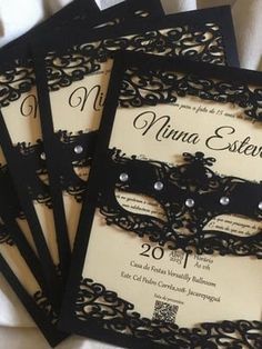 three black and white masks are on top of the wedding card, which is decorated with pearls