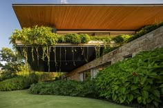 the house is surrounded by greenery and stone walls, along with lush green plants