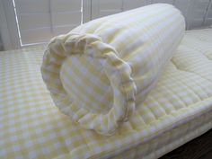 a yellow and white checkered pillow sitting on top of a bed