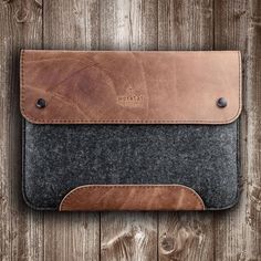 a leather and felt sleeve on a wooden surface