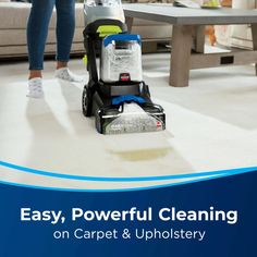 a woman is cleaning the floor with a carpet cleaner