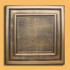 a square metal plate with an intricate design on the front and back side, against a yellow background