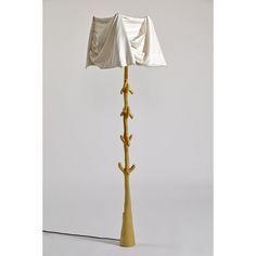 a lamp that is sitting on top of a table next to a white wall and floor