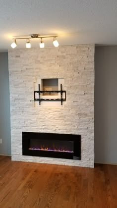 an empty room with a fireplace and tv mounted on the wall