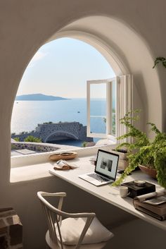 a laptop computer sitting on top of a white desk next to a potted plant