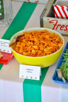 there is a bowl full of pasta and other food items on the table at this party