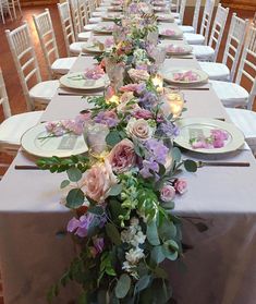 a long table is set with plates and flowers