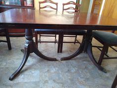 a wooden table with chairs around it in a room that has tile flooring and walls