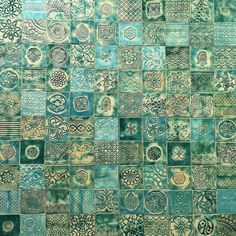 a blue and green tiled wall with different designs