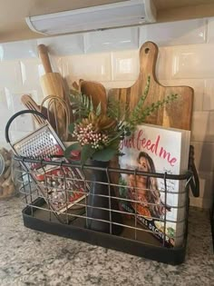 a metal basket filled with cooking utensils and cookbooks on top of a kitchen counter