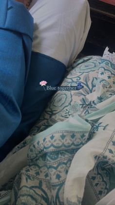 a person laying in bed with blue and white sheets