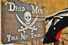 a wooden sign that says dead men tell no tales with a pirate's skull and crossbones on it