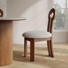 a wooden table and chair with a white cushion on the seat next to a round dining room table