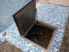 an open box sitting on top of a blue and white tiled floor next to a wall