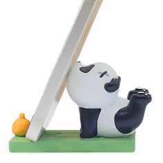 a small figurine of a panda bear leaning up against a computer monitor screen