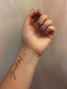 a woman's wrist with a small tattoo on it that reads, happy mother