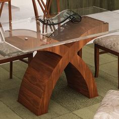 a glass table with wooden chairs and a bench in front of it on the floor