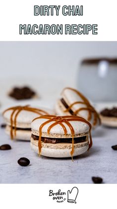 two macaron sandwiches with caramel sauce drizzled on top and chocolate chips scattered around them