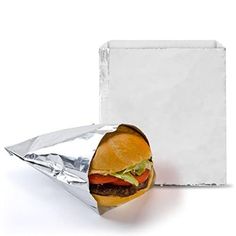 a sandwich wrapped in aluminum foil next to a white box