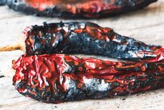 two pieces of burnt food sitting on top of a wooden table next to each other