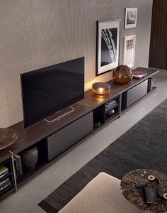 a flat screen tv sitting on top of a wooden entertainment center in a living room