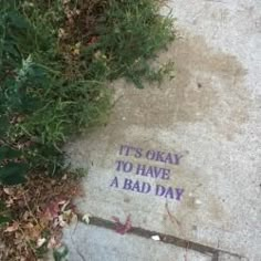 it's okay to have a bad day written on the sidewalk next to some grass