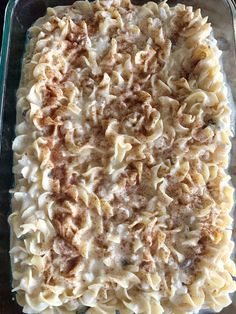 an uncooked casserole dish with pasta and meat toppings on it