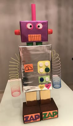 a cardboard robot made to look like it is playing with some sort of game on the table