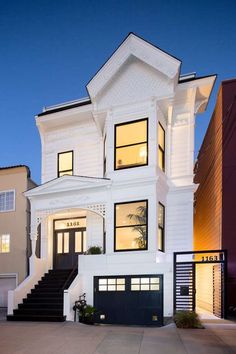 a large white house with stairs leading up to the front door and second story window