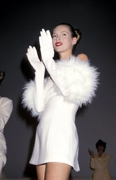 a woman in a white dress and gloves