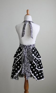 a mannequin wearing a black and white dress with polka dots on the skirt