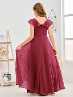 the back of a woman in a long red dress, with her hands on her hips