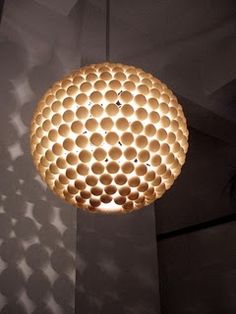 a light that is hanging from the ceiling in front of a wall with circles on it