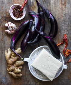 an assortment of vegetables including eggplant, cauliflower and garlic on a wooden table