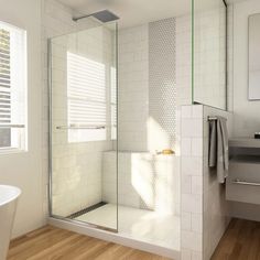 a bathroom with a stand up shower next to a white bath tub and wooden floors